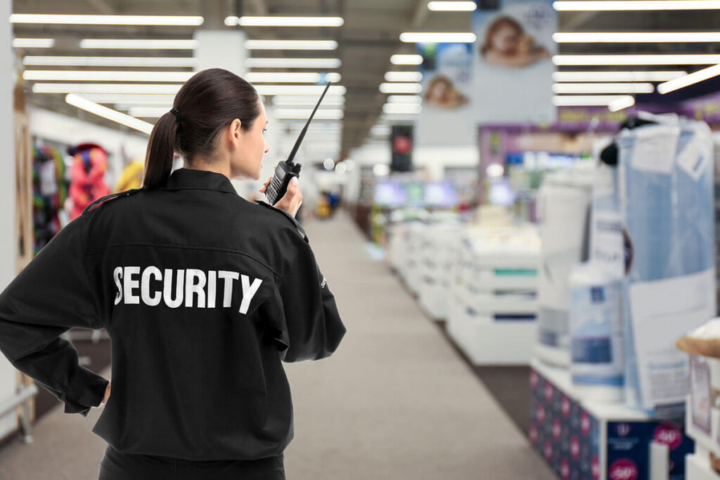 Security guard using portable radio transmitter in shopping mall